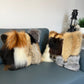 Two fur pillows on a sofa. 