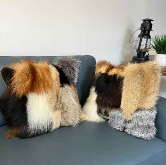 Two fur pillows on a sofa. 